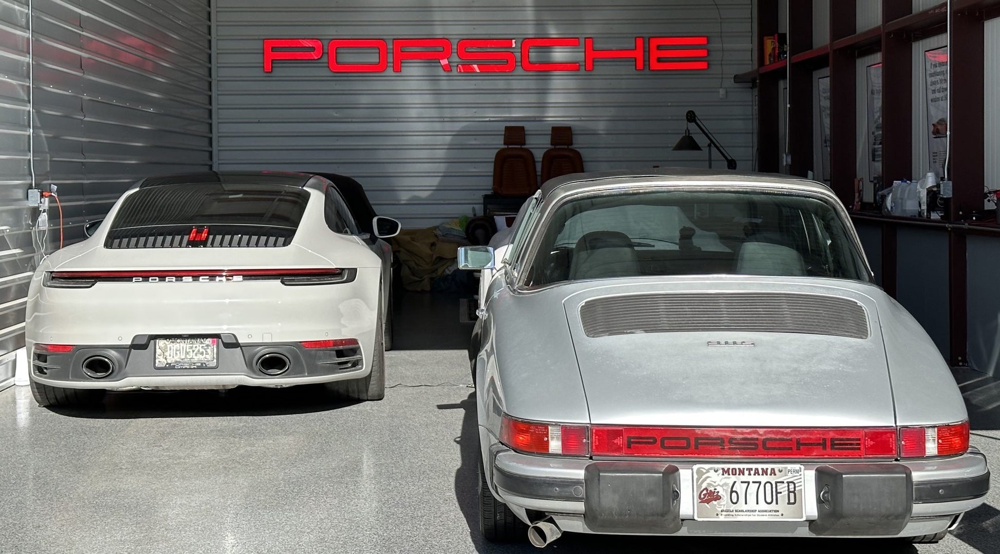 A red LED sign with the Porsche logo illuminated on a wall